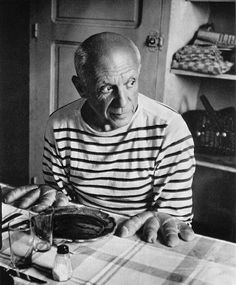 an old man sitting at a table with food