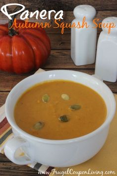 there is a bowl of soup on the table with pumpkins and milk in the background