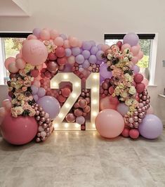 balloons and flowers are arranged in the shape of the number twenty nine surrounded by large letters