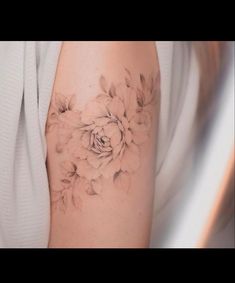 a woman's arm with a flower tattoo on the left side of her arm