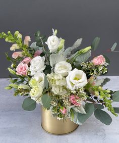 a vase filled with white and pink flowers sitting on top of a marble countertop