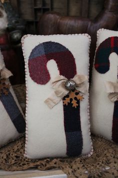 three decorative christmas pillows sitting on top of a table