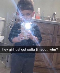 a young boy standing in front of a bathroom mirror holding a light up to his face