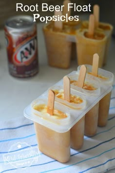 three popsicles in plastic containers with wooden sticks sticking out of them and text overlay reading root beer float popsicles