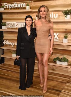 two women standing next to each other on a wooden floor