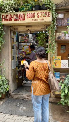 a woman standing in front of a book store