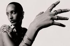 a black and white photo of a woman with her hands in the air while wearing rings