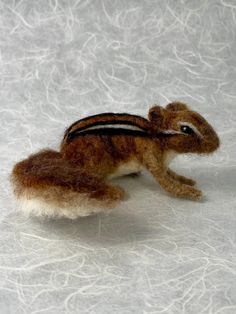 This darling chipmunk is needle-felted over a wire armature of pure wool, with a lush pelt of variegated browns. The wire armature allows for gentle posing. His wee eyes are needle-felted as is his nose. He is life sized, standing approximately 2.5  inches tall and 5 inches long. He would make a beautiful addition to a woodland scene or a seasonal creature on a nature table. He also can be nestled in a Christmas tree!  I make each of my creations with love, attention to detail and in a smoke free home. This chippy is not intended as a child's toy and is best for ages 12 and up. Keep away from pets, as they just love the wool! He is in stock and ready to be shipped. I carefully pack and ship via USPS. When he is shipped you will be notified with a tracking number that day. I can combine shi Needle Felted Chipmunk, Water Felting, Wire Armature, Woodland Scene, Nature Table, Forest Creatures, That Day