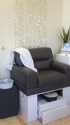 a living room with a black leather couch and white side table in front of it