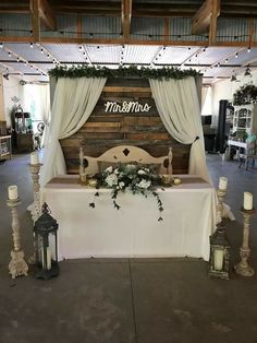 a table with candles and flowers on it in front of a sign that reads, miss and mrs