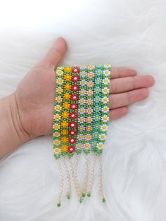 a hand is holding three bracelets with beads