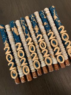 several blue and white decorative objects on a wooden table with gold letters painted on them