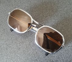 Awesome 1980s metal sunglasses, maybe late 1970s. I love the geometrical and silver metal frame, totally matching the era. It says 'MARA' on the inside. In very good vintage condition, minor signs of use. Width: 13 cm / 5.1 in.  Dimensions glasses including the frame about 4.25 x 5.5 cm / 1.75 x 2.15 in Please note: only the glasses as shown, no extras and no box. Retro Metal Frame Sunglasses, Retro Metal Sunglasses With Gradient Lenses, Retro Silver Metal Sunglasses, Retro Metal Sunglasses With Mirrored Lenses, Retro Metal Sunglasses With Tinted Lenses, Retro Tinted Metal Sunglasses, Retro Silver Sunglasses With Metal Frame, Vintage Metal Sunglasses With Gradient Lenses, Vintage Silver Sunglasses With Metal Frame