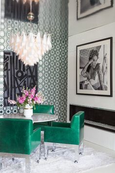 a dining room with green chairs and pictures on the wall