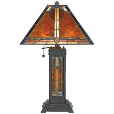 a lamp that is sitting on top of a wooden stand with a stained glass shade