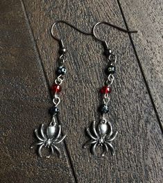 Gothic spider drop earrings handmade by me! Each earring features two black stone beads, a red glass bead, and a pewter spider charm.  Ear wires are nickel-free.  Each earring is about 5cm/2in from bottom of ear wire down, and spider charms are about 1.5cm/0.6in across. Perfect simple accessory for goths, emos, witches, or just Halloween enthusiasts! Gothic Earrings Diy, Goth Earrings Diy, Spiderman Earrings, Goth Accessories Jewellery, Beaded Spider Earrings, Pretty Silver Jewelry, Emo Earrings, Gothic Spider, Emo Accessories