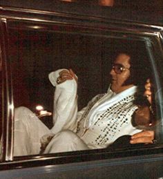 a man and woman sitting in the back of a car