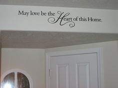 a sign that says, may love be the heart of this home above a door