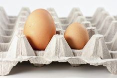 two brown eggs in an egg carton