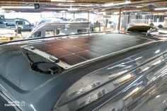 solar panel on the roof of a car in a garage with other cars behind it