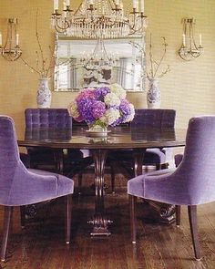 a dining room table with blue chairs and a chandelier