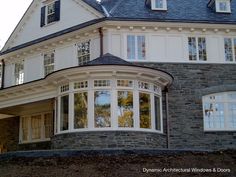 a large white house with lots of windows on it's sides and an arched window