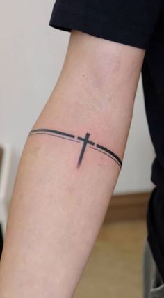 a person with a cross tattoo on their arm