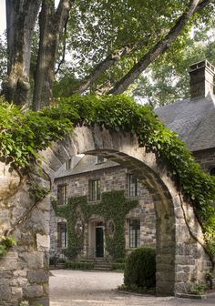 an old stone house with ivy growing on it's walls and arched doorways