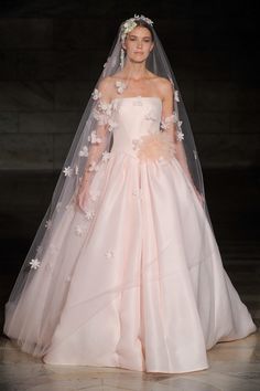 a woman in a wedding dress on the runway