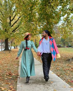 a man and woman walking down a sidewalk holding hands