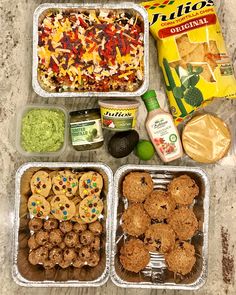 four containers filled with food sitting on top of a counter next to a bag of chips