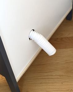 a white wall mounted on the side of a bed with a hose attached to it