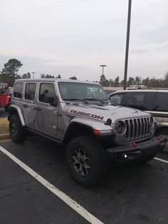 a silver jeep parked in a parking lot