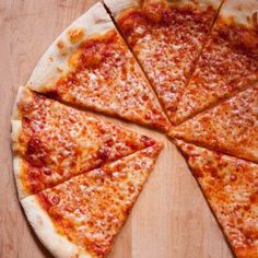 a sliced pizza sitting on top of a wooden cutting board