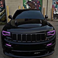 the front end of a black jeep with purple lights on it's grilles