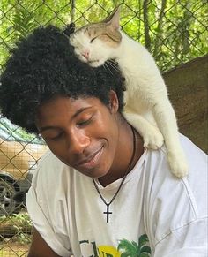 a cat sitting on top of a woman's head