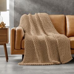 a couch with a white knitted blanket on it