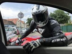 a person wearing a helmet and gloves sitting in a car