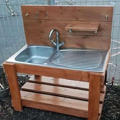 an outdoor sink made out of wooden pallets and metal faucet, sitting on the ground