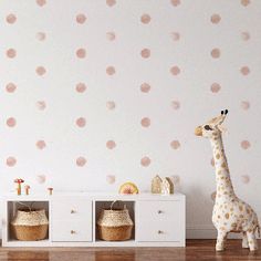 a toy giraffe standing in front of a wall with polka dots on it