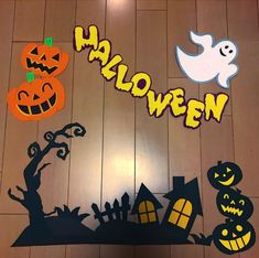 a wooden floor with halloween cutouts on it and the word halloween written in large letters