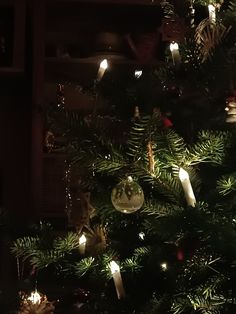 a christmas tree with candles and ornaments on it