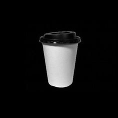 a black and white photo of a coffee cup on a dark background with the lid down