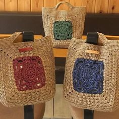 two purses sitting on top of a wooden bench