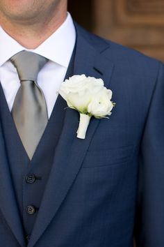 a man in a suit and tie with a boutonniere on his lapel