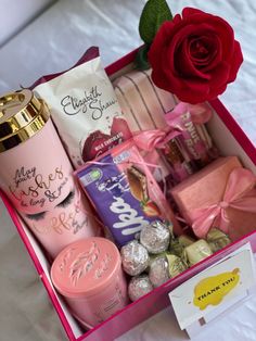 a pink box filled with lots of different types of items next to a red rose