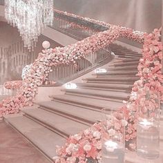 a staircase decorated with pink flowers and candles