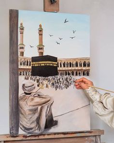 a man is painting an islamic scene on a canvas