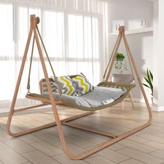 a swing bed with pillows on it in a living room next to a potted plant