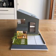 a model house sitting on top of a wooden table